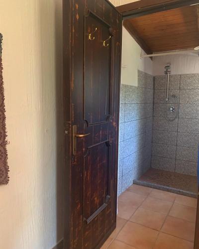 a large wooden door in a bathroom with a shower at S'Imbragu Farm B&B in Tortolì