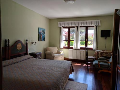 ein Schlafzimmer mit einem Bett, einem Stuhl und einem Fenster in der Unterkunft Posada La Merced in Loredo