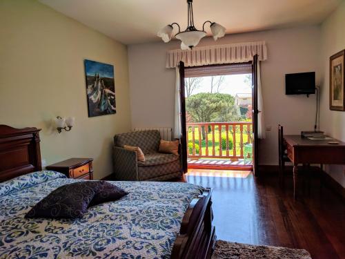 a bedroom with a bed and a chair and a window at Posada La Merced in Loredo