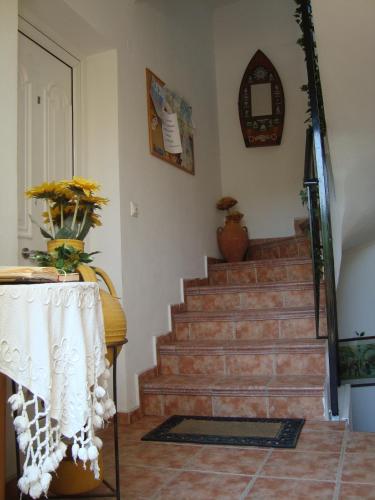 a room with a staircase with a vase of flowers at Green Hill Studios & Apartments in Kokkari