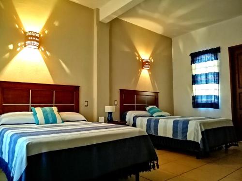 a bedroom with two beds in a room at Paraje La Huerta in Oaxaca City