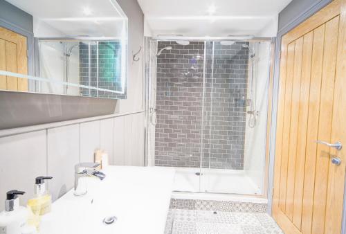 a bathroom with a shower and a white sink at Willowbeck Lodge Boutique Hotel in Carlisle