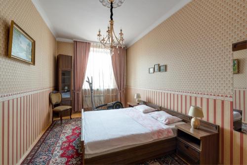 a bedroom with a bed and a chandelier at Апартаменты в центре Минска in Minsk