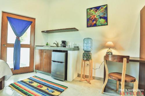 a room with a kitchen with a table and a chair at Mar y Sueños in Sayulita