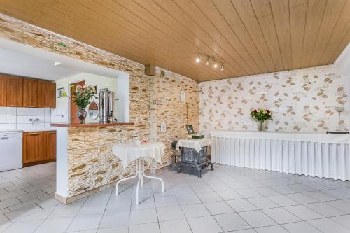 a kitchen with a white table and a brick wall at Dom Gościnny Marcela in Rewal