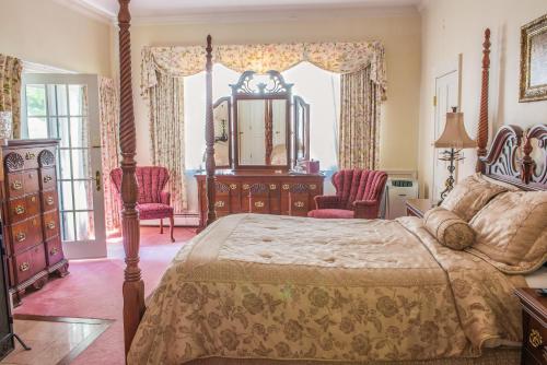 a bedroom with a bed and a dresser and chairs at Chiltern Inn in Bar Harbor