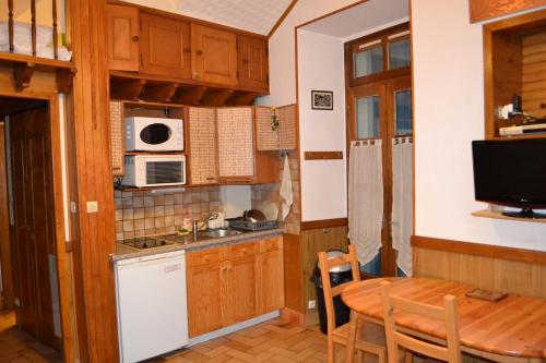 a small kitchen with a table and a microwave at Appartement Résidence Napoléon in Cauterets