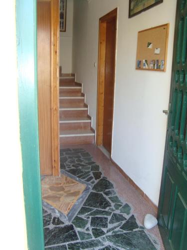a hallway with a stone floor and a staircase at Green Hill Studios & Apartments in Kokkari
