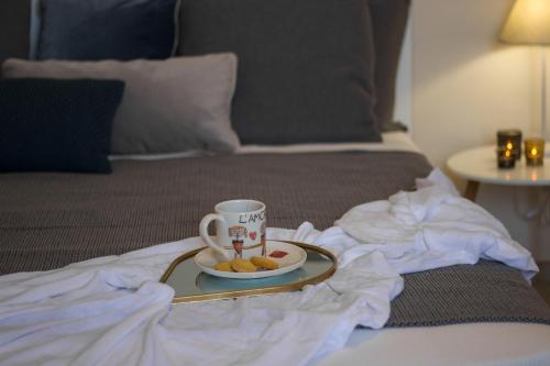 a tray with a cup and a plate of food on a bed at Casa del Teatro in Città della Pieve