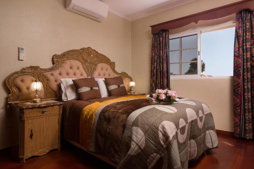 a bedroom with a large bed and a window at Paradise House Calheta in Calheta