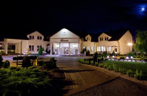 a large white house at night with lights at Dworek Jolanta in Biała Podlaska