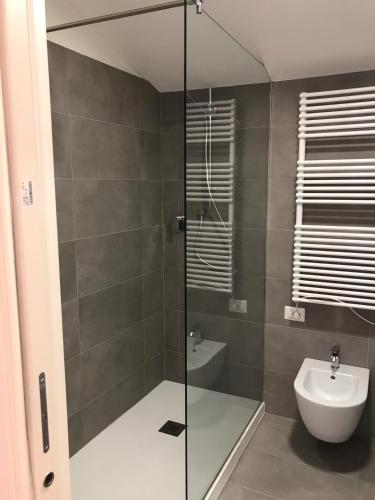 a bathroom with a shower with a toilet and a sink at Cinema House Apartments in Orbetello