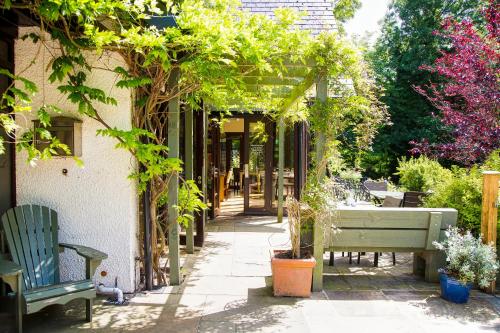 a garden with a bench and trees and a building at Willowbeck Lodge Boutique Hotel in Carlisle