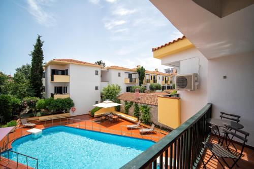 a balcony with a swimming pool and a building at Elia Apartments in Afitos