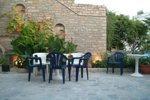four chairs and a table in a patio at Green Hill Studios & Apartments in Kokkari