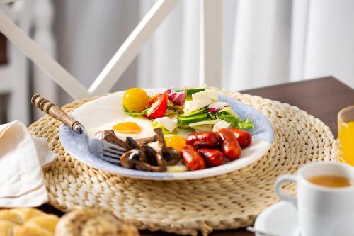 a plate of food with eggs and vegetables on a table at New Era Hotel Old Town Bucharest- parking with fee nearby - NOT at the hotel ! in Bucharest
