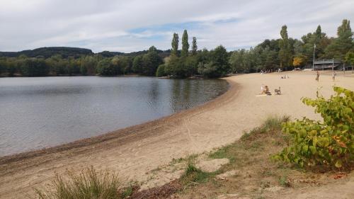 a beach with people on it next to a body of water at Chez Sivade Gîte in La Crouzille