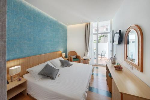 a bedroom with a white bed and a blue wall at Hotel Villa Adriatica - Adults Only in Supetar