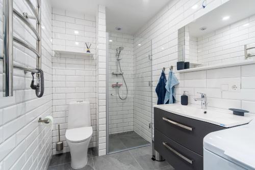 e bagno con servizi igienici, lavandino e doccia. di Lovely Oldtown Apartment a Klaipėda