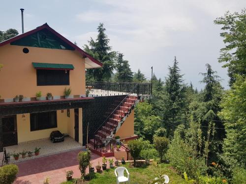a house with a staircase leading up to it at Aditya Homestay Dalhousie in Dalhousie