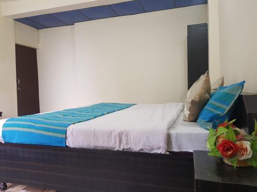 a bed with blue and white sheets and pillows at Aditya Homestay Dalhousie in Dalhousie