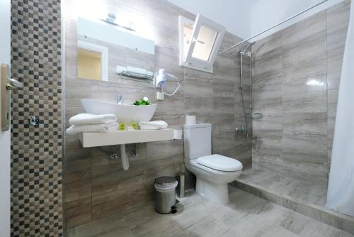 a bathroom with a toilet and a sink and a shower at Limnia Gi in Mirina