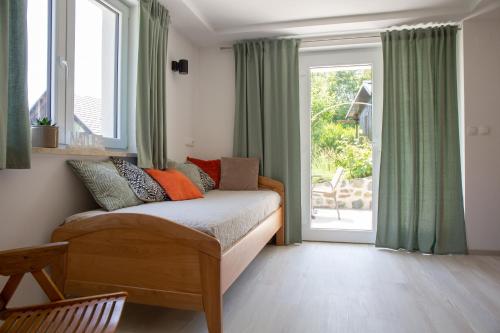 a bedroom with a bed with green curtains and a window at Apartments Korošec in Bled