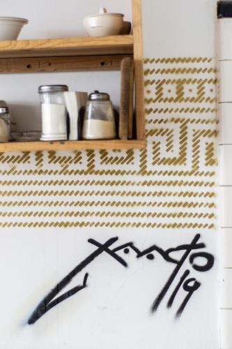 a sign on a wall next to a shelf at Gente de Más Bnb in Puebla