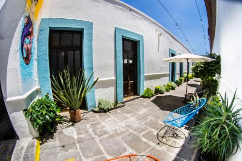 un banco azul sentado fuera de un edificio con plantas en Gente de Más Bnb en Puebla