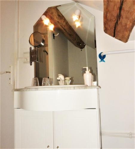 une salle de bain avec un lavabo et un miroir dans l'établissement Le Cottage du Château, à Chaudenay-le-Château