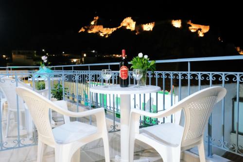 a white table and chairs on a balcony at night at Limnia Gi in Mirina