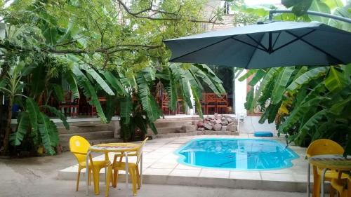 a pool with a table and chairs and an umbrella at El Viejo Molino in Chilecito