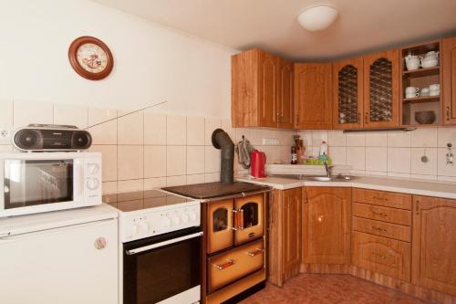 uma cozinha com armários de madeira e um micro-ondas branco em Chalupa Otava em Sušice