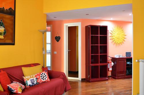 ローマにあるEdo House Monteverdeの赤いソファと黄色の壁のリビングルーム