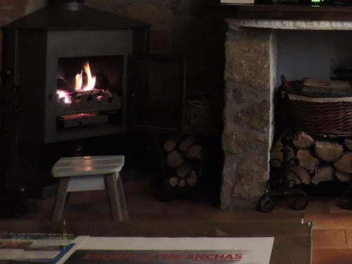 a fireplace with a chair and a fire in it at La Covatilla III in La Hoya
