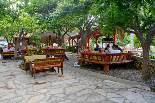 Un groupe de personnes assises sur des bancs dans un parc dans l'établissement Cinar Sahil Pansiyon, à Dalyan