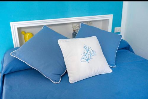 a bed with blue and white pillows on it at CASA SOFIA in Anacapri