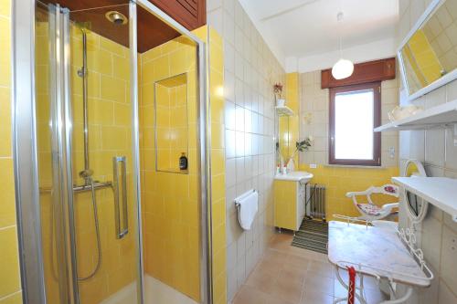 ein gelbes Badezimmer mit einer Dusche und einem Waschbecken in der Unterkunft Villa Walter in Sorrent