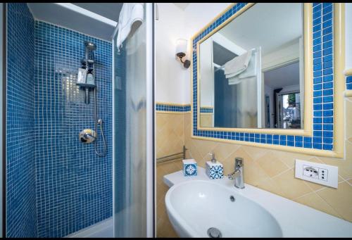 a bathroom with a sink and a shower with a mirror at CASA SOFIA in Anacapri