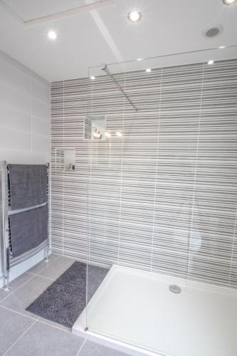 a shower with glass doors in a bathroom at Altahammond House in Carrickfergus