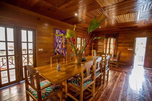 una sala da pranzo in legno con tavolo e sedie in legno di Roça Saudade Guest House a Trindade