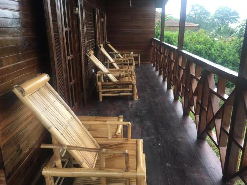 a row of chairs on the porch of a cabin at Roça Saudade Guest House in Trindade