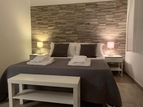 a bedroom with a large bed with two tables and two lamps at BeB L'ALLORO in Pachino