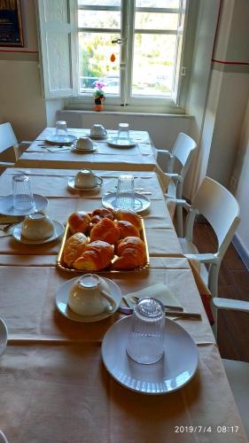 a long table with croissants and plates on it at Le rondini di San Donato in Lucca