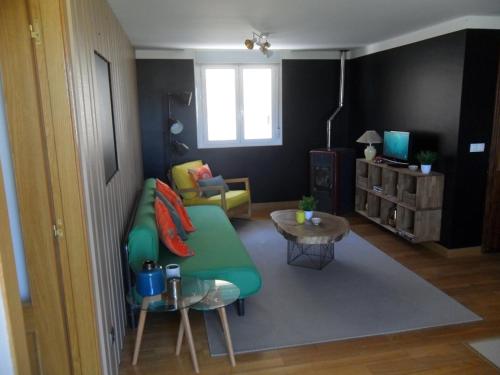 a living room with a green couch and a table at Bienvenidos a vuestra casa! in Sansoáin