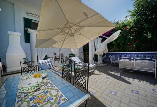 a patio with a table with a large umbrella at CASA SOFIA in Anacapri