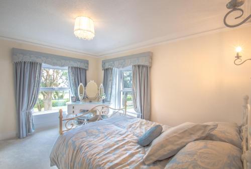 a bedroom with a bed and a large window at Altahammond House in Carrickfergus
