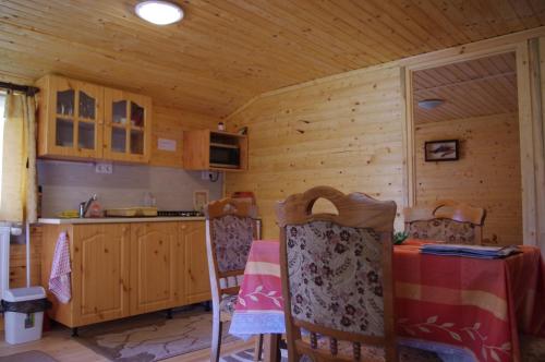 a kitchen with a table and chairs in a cabin at Horváth Kert Vendégház in Zirc