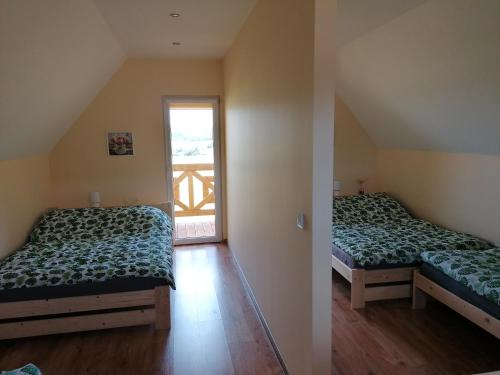 two beds in a room with a window at Domki pod Derkaczem in Wünschelburg