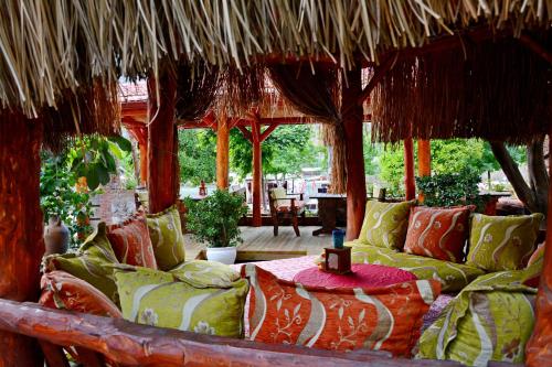 a room with a bed with pillows and a straw roof at Cinar Sahil Pansiyon in Dalyan